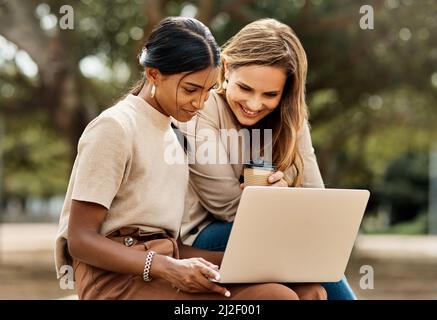 Smart est quelque chose que vous devenez pas quelque chose que vous êtes. Prise de vue de deux jeunes étudiantes attrayantes à l'aide d'un ordinateur portable, assis à l'extérieur sur le campus. Banque D'Images