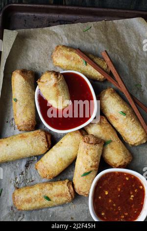 Vue de dessus des petits pains aux œufs en sauce aigre-douce sur une table rustique sombre avec des bâtonnets de broyage. Garni d'oignons verts. Vue du dessus de la table au plafond. Banque D'Images