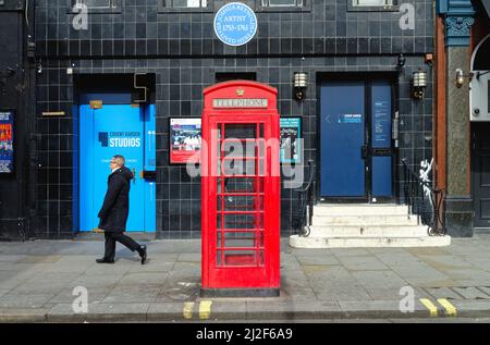 Un téléphone rouge britannique emblématique dans Great Newport Street, Covent Garden Central London, Angleterre, Royaume-Uni Banque D'Images