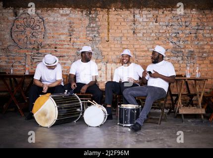 Jouer au rythme brésilien. Tourné d'un groupe jouant leurs instruments de percussion dans un cadre brésilien. Banque D'Images