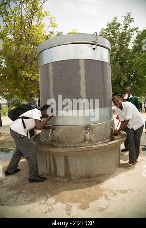 Les élèves de l'école ont accès à de l'eau potable et à l'eau de lavage propre à partir d'une fontaine dans leur cour d'école dans la région d'Oshana, en Namibie, en Afrique. Banque D'Images