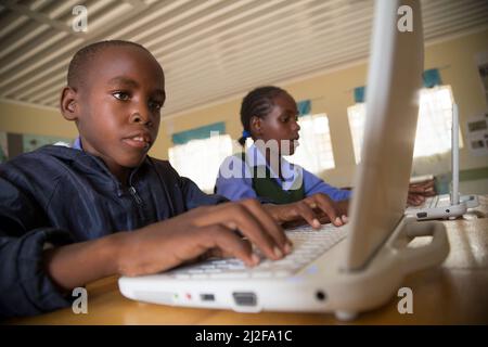 Les élèves Moses Wileinge (13, l) et Irena Nghidengwa (13, r) apprennent avec de nouveaux ordinateurs portables à l'école Shikudule Combined School, dans la région d'Oshana, en Namibie. En tant que partie o Banque D'Images