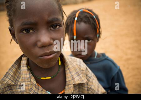 Fille avec des tresses traditionnelles de cheveux et une expression triste dans la région d'Omusati, Namibie, Afrique du Sud-Ouest. Banque D'Images