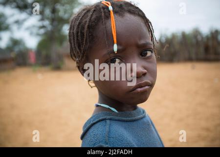Fille avec des tresses traditionnelles de cheveux et une expression triste dans la région d'Omusati, Namibie, Afrique du Sud-Ouest. Banque D'Images