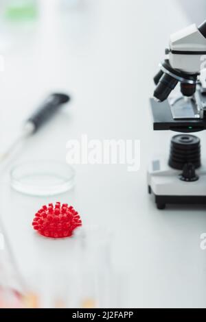 modèle de bactéries coronavirus rouge et microscope flou en laboratoire bio,image de stock Banque D'Images
