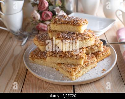 Plateau à gâteau avec gâteau frais caramélisé en feuille d'amande. Servi empilé sur une table en bois. Banque D'Images