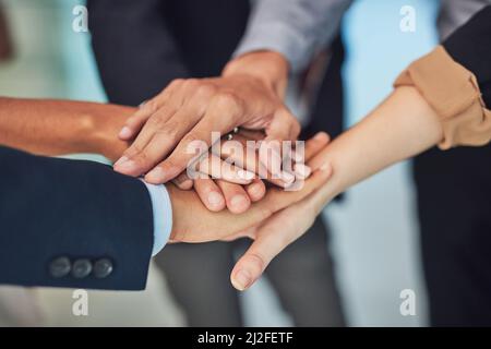 Réuntons-vous et faisons fonctionner cette tâche. Gros plan d'un groupe d'hommes d'affaires méconnus qui forment un caucus avec leurs mains tout en étant debout dans le Banque D'Images