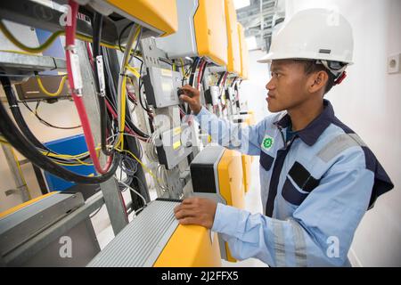 Un technicien en électricité exploite des équipements dans une centrale d'électricité solaire sur l'île de Karampuang, en Indonésie, en Asie. Banque D'Images