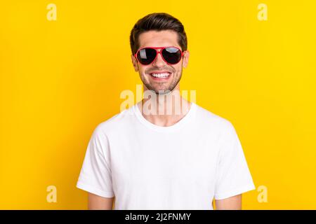 Photo de brunet millennium funky porte lunettes t-shirt isolé sur fond jaune Banque D'Images