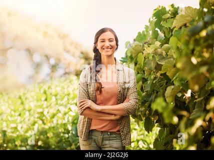 J'adore travailler toute la journée au soleil. Portrait d'un jeune agriculteur joyeux posant dans les champs de sa ferme. Banque D'Images