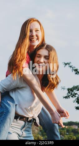 Deux heureux joyeux jeune fille aimante amis ayant l'amusement sur fond de nature. Deux amis Gen z Millennials dansant et jouant dans le pré Banque D'Images