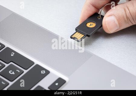 Galice, Espagne; 1 avril 2022: Main tenant une clé de matériel Yubikey. Yubikey est un dispositif d'authentification matériel fabriqué par Yubico Banque D'Images