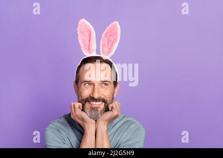 Image de gros plan d'un drôle d'apparence douce mâle avec des oreilles de lapin ont l'air vide de l'espace isolé sur fond violet de couleur Banque D'Images