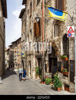 Une belle photo d'une rue au sol en pierre avec des boutiques de souvenirs dans le centre historique de Gubbio, région de l'Ombrie, Italie Banque D'Images