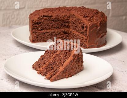 Gâteau de dattes, de chocolat et de patates douces avec tranche coupée sur une assiette séparée Banque D'Images