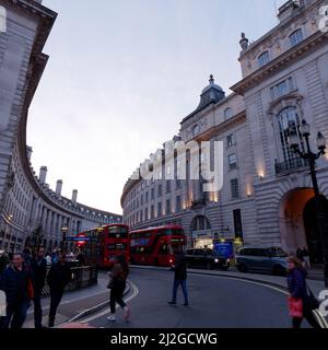 Circulation dans Regent Street avec des piétons près de la station de métro Piccadilly Circus, Londres. Banque D'Images