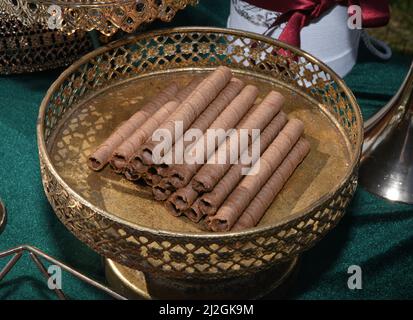 Rouleau de bâtonnets de cachets au chocolat, croquant de cachets dans l'assiette, délicieux, sucré, en-cas. Tubes à chocolat avec garniture au chocolat, dessert de gaufres Banque D'Images