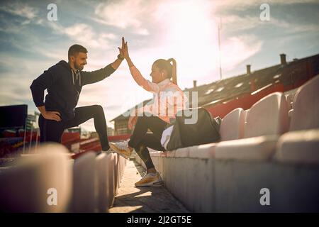 satisfait beardy gars et belle femme donnant haut-cinq les uns aux autres après l'entraînement réussi, souriant Banque D'Images
