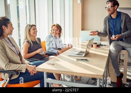 Un groupe de collègues multiethniques qui se chamatent d'une pause dans le bureau Banque D'Images