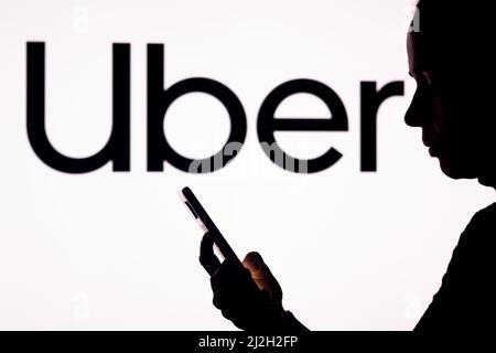 Brésil. 1st avril 2022. Dans cette illustration, la silhouette d'une femme tient un smartphone avec le logo Uber technologies en arrière-plan. (Credit image: © Rafael Henrique/SOPA Images via ZUMA Press Wire) Banque D'Images