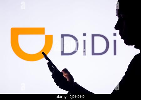 Brésil. 1st avril 2022. Dans cette illustration, la silhouette d'une femme tient un smartphone avec le logo Didi Chuxing en arrière-plan. (Credit image: © Rafael Henrique/SOPA Images via ZUMA Press Wire) Banque D'Images