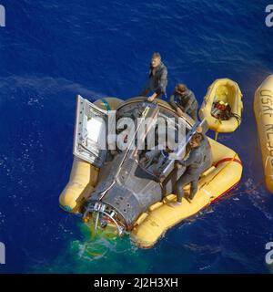 Les astronautes Neil Armstrong (à droite) et David Scott (à gauche) s'assoient avec leurs trappes ouvertes en attendant l'arrivée du navire de récupération, l'USS Leonard F. Mason, après la réussite de leur mission Gemini VIII. Ils sont assistés par les sauveteurs de la U.S. Air Force Paraemen, qui ont sauté à leur vaisseau spatial. Banque D'Images