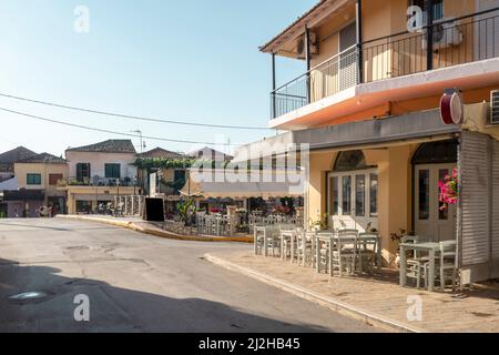 Grèce, Lefkimmi, rue et café-terrasse vides Banque D'Images