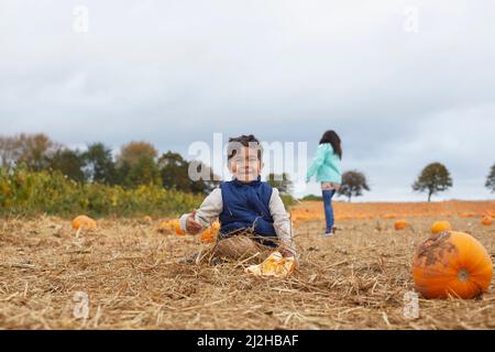 Frère et sœur jouant dans le champ de citrouille Banque D'Images