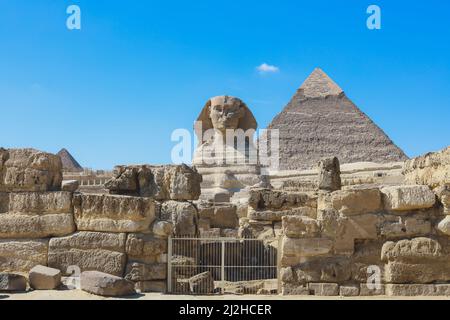 Vue principale sur le Grand Sphinx de Gizeh avec la Grande Pyramide en arrière-plan à Gizeh, Égypte Banque D'Images