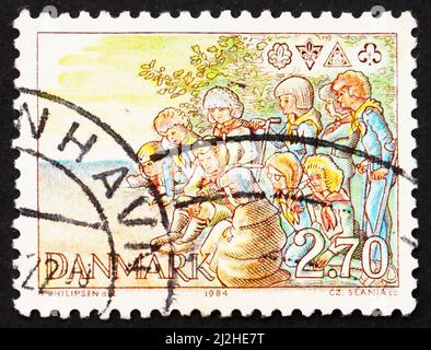 DANEMARK - VERS 1984 : un timbre imprimé au Danemark montre des Scouts autour de Campfire et d'Emblems, vers 1984 Banque D'Images
