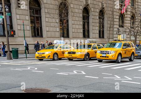 Taxis jaunes, trois différents types de voitures, attendant que le feu de signalisation devienne vert, traverse devant, Fifth Avenue, avec des personnes marchant Banque D'Images