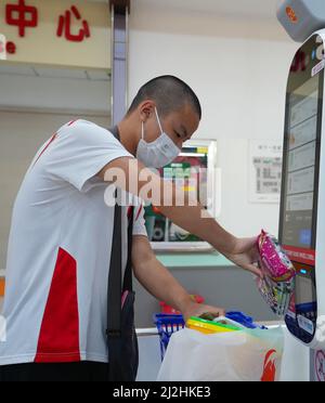 Haikou, province chinoise de Hainan. 23rd mars 2022. Chen Xingrong dans un supermarché à Haikou, dans la province de Hainan, au sud de la Chine, le 23 mars 2022. POUR ALLER AVEC 'China Focus: Adolescent avec l'autisme nains vers la victoire' Credit: Li Duojiang/Xinhua/Alamy Live News Banque D'Images