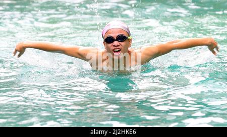 Haikou, province chinoise de Hainan. 23rd mars 2022. Chen Xingrong fait un exercice de natation dans une piscine à Haikou, dans la province de Hainan, au sud de la Chine, le 23 mars 2022. POUR ALLER AVEC 'China Focus: Adolescent avec l'autisme nains vers la victoire' Credit: Li Duojiang/Xinhua/Alamy Live News Banque D'Images