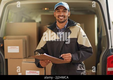 Les livraisons sont effectuées dans les délais prévus. Portrait d'un liveur souriant debout devant sa camionnette tenant un colis. Banque D'Images