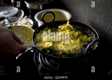 Un gros plan de l'en-cas indien appelé pakoda dans la fabrication. Une recette de pommes de terre marinées. Banque D'Images