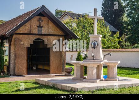 Vue sur la fontaine dans le jardin. Église orthodoxe serbe à Sremska Kamenica - Église de la Nativité de la mère la plus Sainte de Dieu. Banque D'Images