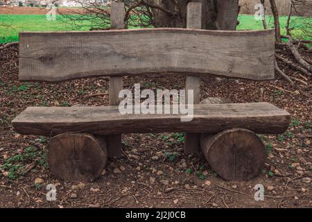 un banc fait avec des troncs d'arbre dans une forêt Banque D'Images