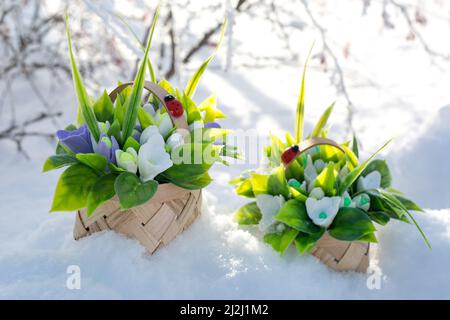 Bouquets de fleurs artificielles et savons sur la neige luxuriante. Banque D'Images