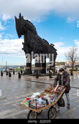 Canakkale, Turquie. Février 18th 2022 Un vendeur de rue vendant des souvenirs à côté de l'emblématique statue de cheval de Troie sur le front de mer de Canakkale, construit pour utilisation Banque D'Images