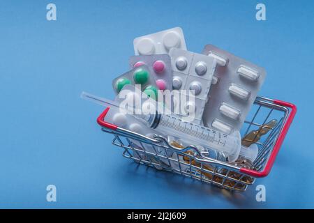 Un panier contenant des préparations médicales sur fond bleu. Banque D'Images