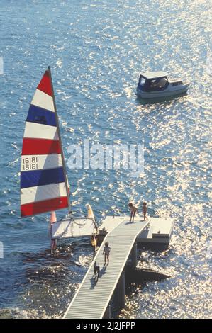 Australie. Sydney. Enfants sur la jetée et le catamaran Hobie Cat avec voile levé. Banque D'Images