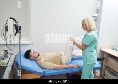 Jeune homme sur un canapé dans un bureau neurologue Banque D'Images