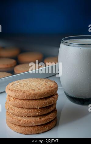 une pile de biscuits avec un verre de glace milka dans un plateau de cuisine sur fond bleu foncé Banque D'Images