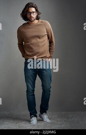 Restez à la pointe des tendances en matière de tenues décontractées. Photo studio d'un beau jeune homme posant sur un fond gris. Banque D'Images