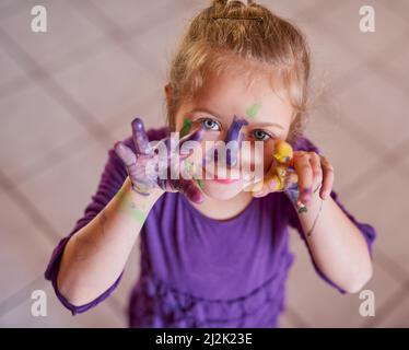 Devenir l'art Portrait court d'une petite fille avec ses mains et son visage couverts de peinture. Banque D'Images