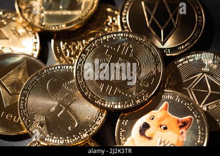 Gros plan d'un Bitcoin doré dans une pile, entre autres crypto-monnaies numériques. Banque D'Images