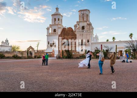 Une mariée et un marié photographiés devant la Mission San Xavier del bac à Tucson, Arizona, États-Unis. Banque D'Images