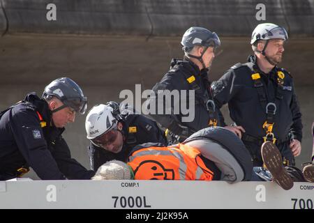 Grays, Thurrock, Royaume-Uni 2 avril 2022 Arrêt des manifestants pétroliers pour bloquer les routes au dépôt pétrolier de Thurrock. Quatre manifestants ont grimpé à bord d'un pétrolier se fixant sur le toit avec des écluses tandis qu'un autre groupe a créé une structure en bois qui couvrait un tunnel creusé sous la route. Les quatre manifestants ont été enlevés par les services d'urgence à l'aide d'une civière et ont été arrêtés par la suite. Crédit : Denise Laura Baker/Alay Live News Banque D'Images