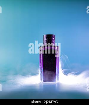 Bouteille rose d'eau parfumée sur fond bleu avec éléments de fumée Banque D'Images