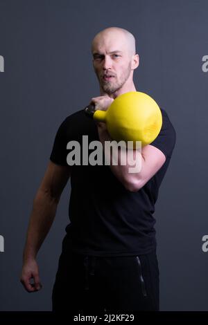 Guy avec un jaune kettlebell gym anonyme jeune force, dans l'après-midi motivation adolescent pour les hommes et plancher sportswear, philippin vietnamien. Guy Banque D'Images